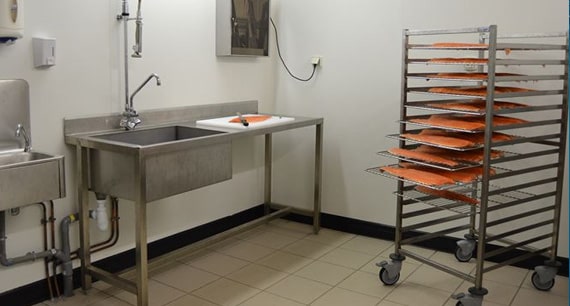 Atelier de pr&eacute;paration et transformation de truite avec filets sur chariot inox
